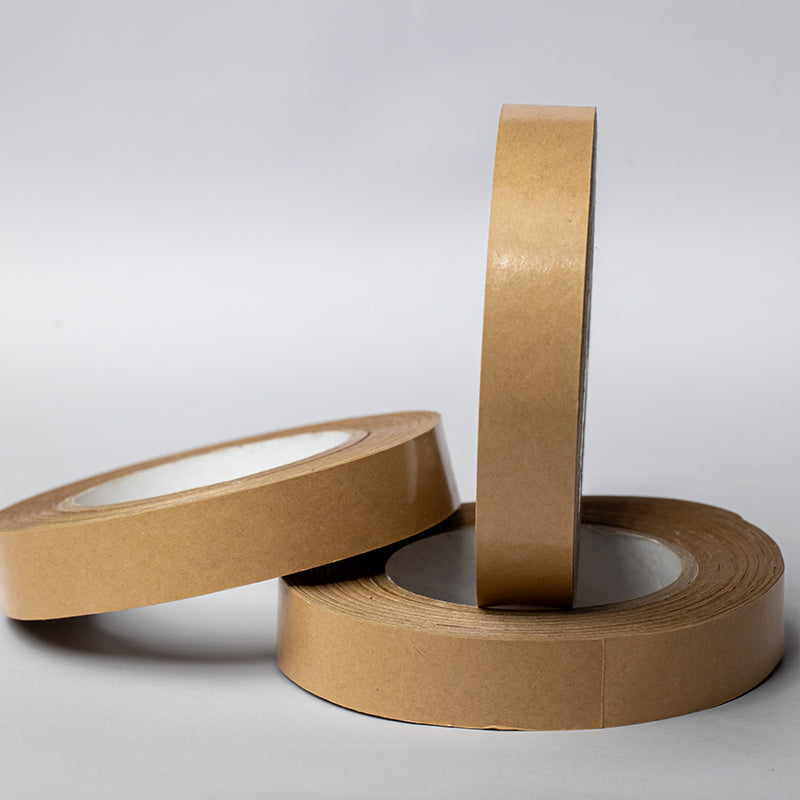Side view of three one-inch brown packing tape rolls showcasing their height - perfect for carton sealing and art projects.